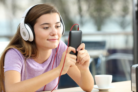 Relaxed teenager listening to music in an hotel bar