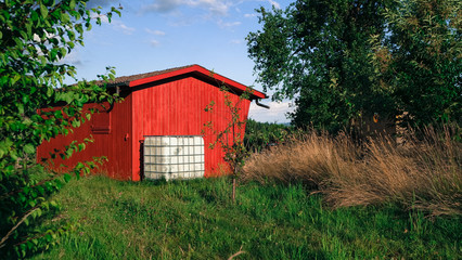 Gem&uuml;tliche rote H&uuml;tte in gr&uuml;ner Landschaft