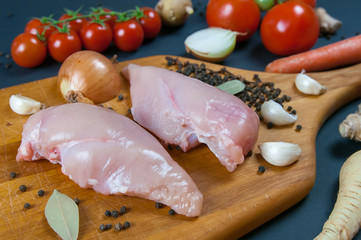 Food background with cooking ingredients at dark stone table. Top view copy space. Sea salt pepper rosemary and tomatoes