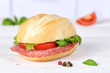 Brötchen Sandwich Baguette belegt mit Salami Schinken auf Holzbrett