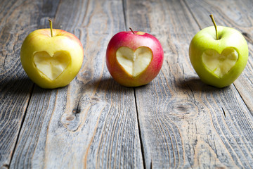 Apples with a cut heart on the wood