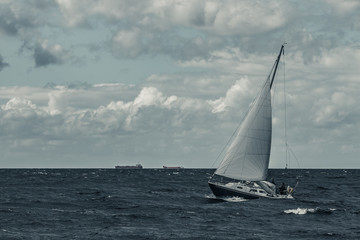 Fototapeta na wymiar Blue sailboat at storm