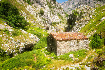The ancient stone shed with a tile roof in mountains
