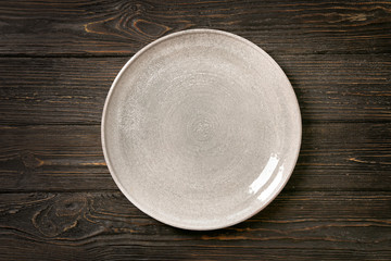 Ceramic plate on wooden background - obrazy, fototapety, plakaty