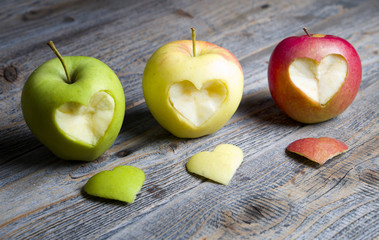Apples with a cut heart on the wood