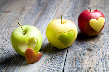 Apples with a cut heart on the wood
