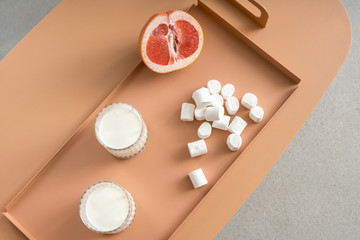 Grapefruit, marshmallows and glasses with milk