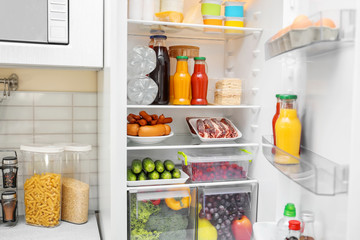 Refrigerator with different products in kitchen