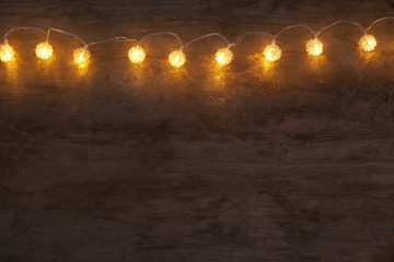 Festive Christmas lights on wooden background