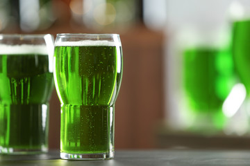 Glass of green beer on table in bar. Saint Patrick's day celebration