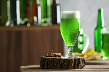 Glass of green beer on table in bar. Saint Patrick's day celebration