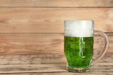 Glass of green beer on wooden background. Saint Patrick's day celebration