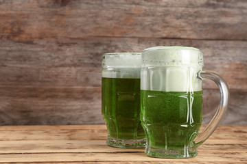Glasses of green beer on wooden background. Saint Patrick's day celebration