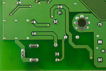 closeup printed circuit board green for background, there are a lot of conductive tracks