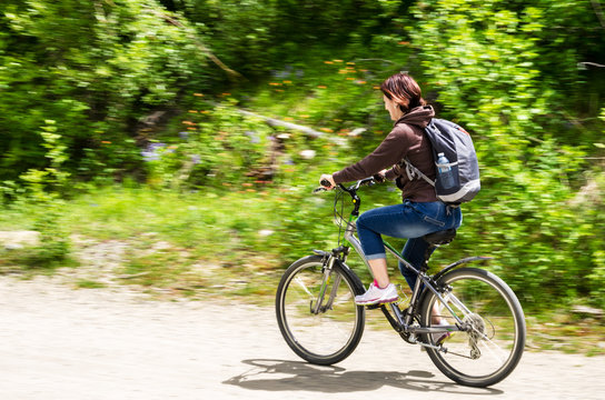 Young Woman Riding a Bicycle on a Sunny Spring Day. Blurred Motion.