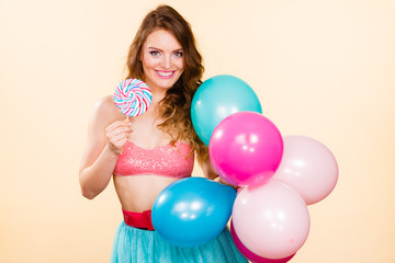 Fototapeta na wymiar Woman holds lollipop candy and balloons