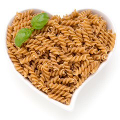 Uncooked wholemeal pasta isolated white background.