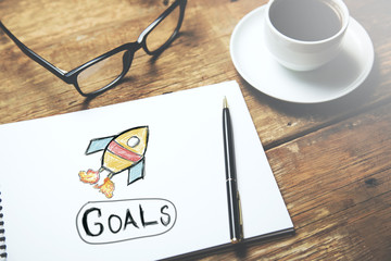 golas text on notepad with coffee