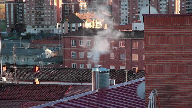  Chimeneas en el tejado de edificios soltando humo