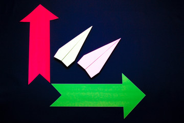 Business concept with paper plane and colored arrows on dark blue background