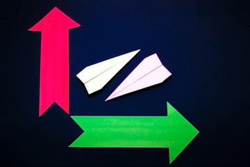 Business concept with paper plane and colored arrows on dark blue background