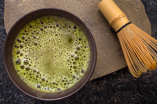 Green matcha tea with whisk. Top view, closeup