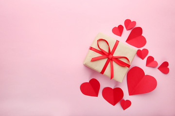 Gift box with red hearts on pink background