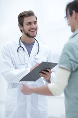 podiatrist writing a prescription to her patient.