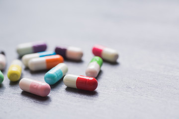 Diversity of colorful different capsules on gray table