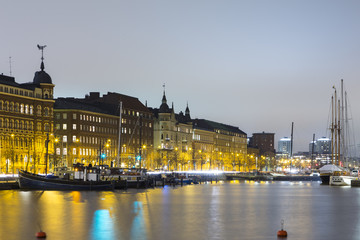 Fototapeta premium Travel Destinations. Line of Traditional Finnish Houses in Helsinki in Front of Waterline of Old Quay, Shot During Blue Hour