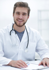 friendly doctor sitting behind a Desk