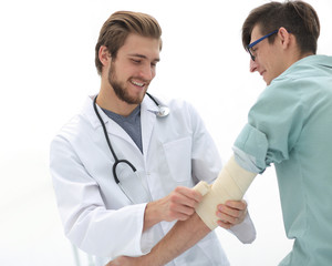 Orthopedist applying bandage onto patient's arm