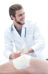 doctor looking at the bandage on the patient's leg