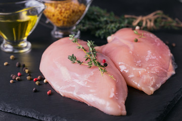 Raw chicken fillets with spices and herbs.