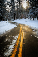 Winter road with snow and sun highlight. portrait orientation. 