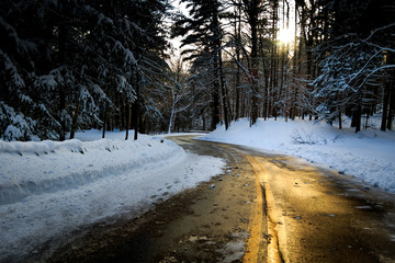 Winter road with snow and sun highlight. Landscape orientation. 