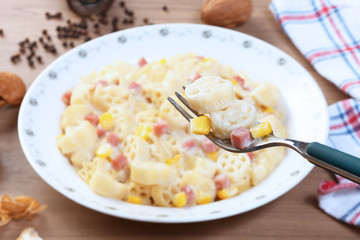 Italian wagon wheel shape pasta with ham and corn