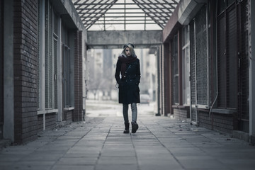 Young woman walking alone through dark passage