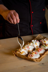 Cooking cookies by hands with white chocolate glaze on wooden background copy text.