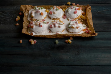 Homemade cookie with fruits and white chocolate glaze on wooden background copy text.