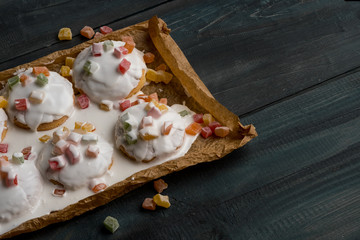 Homemade cookie with fruits and white chocolate glaze on wooden background copy text.