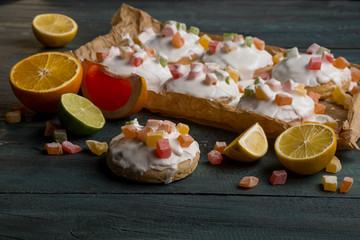 Homemade cookies with fruits and white chocolate glaze on wooden background copy text.