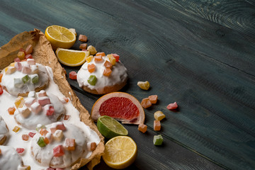 Homemade gingerbread cookies with fruits and icing glaze on wooden dark table.