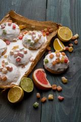 Homemade gingerbread cookies with fruits and icing glaze on wooden dark table.