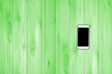 Mobile phone with black screen mock up on wood table background.