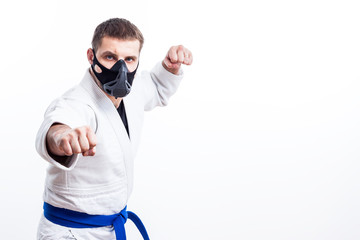 Naklejka premium Young man fighter in a white kimono with blue belt for judo, jujitsu pose on isolated white background