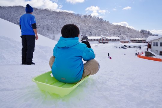スキー場でそり遊びをする子供