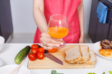 woman with a glass of orange juice in kitchen room