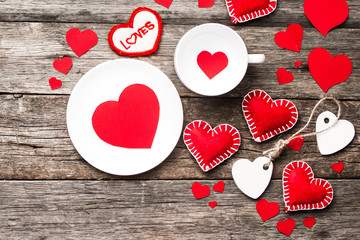 Valentines day background. Red hearts, ribbon, and gift box on wooden background.