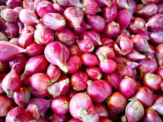Many small shallots are piled up for sale in the bazaar.